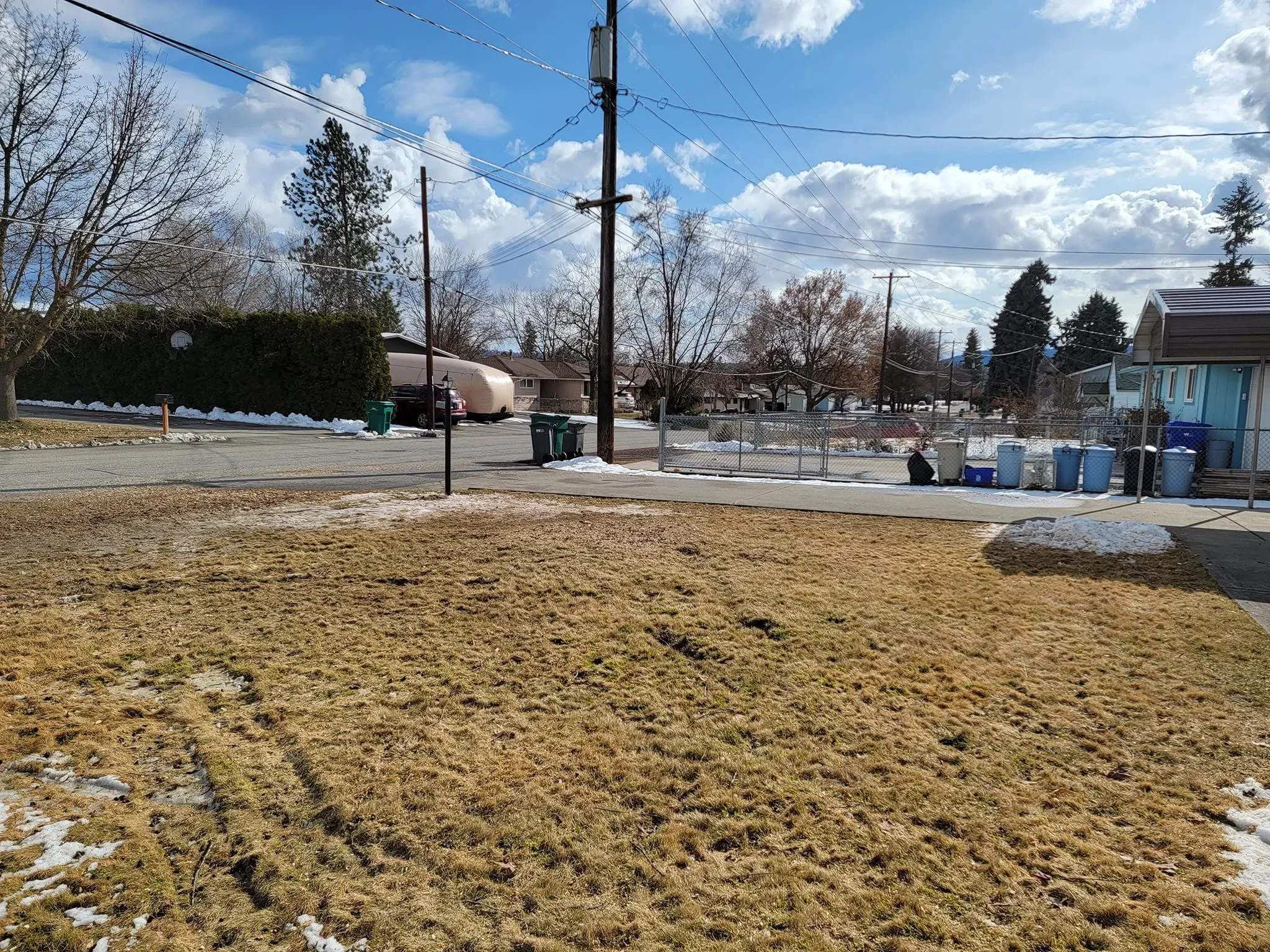 Cleared lot with bare ground, removed trees and brush, utility poles and fencing visible